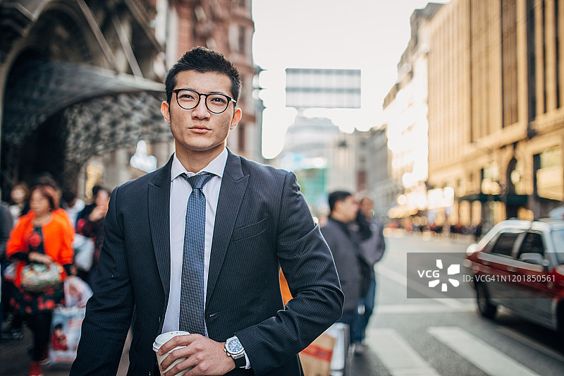 年轻优雅的男人拿着外卖咖啡图片素材