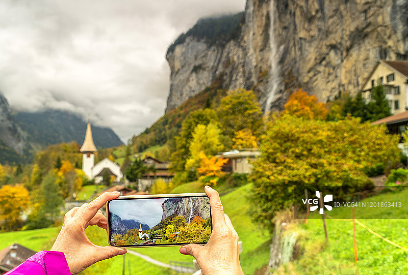 女摄影师在瑞士用手机拍摄劳特布龙嫩小镇图片素材