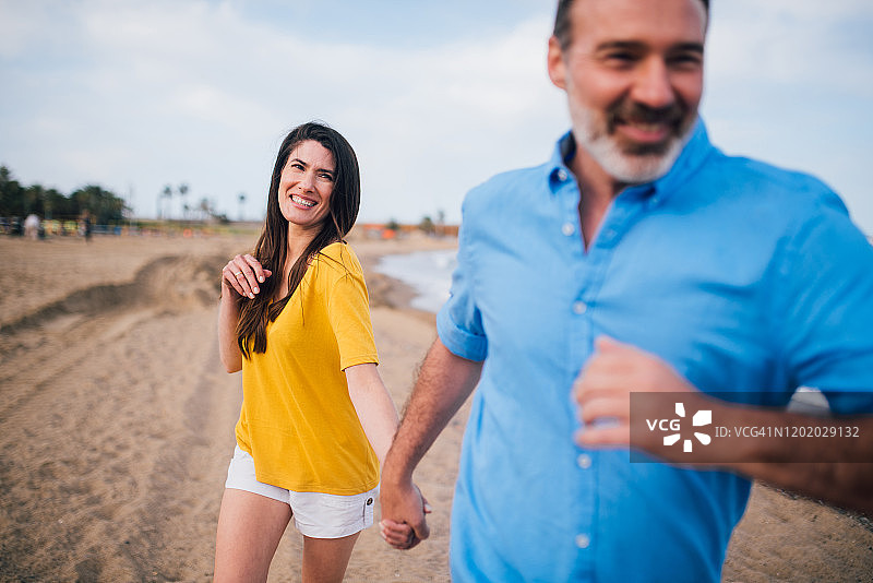 和男人在海滩上享受的女人图片素材