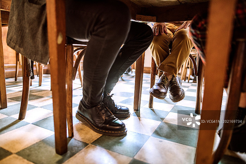 咖啡馆里与朋友小憩的侏儒症男子图片素材