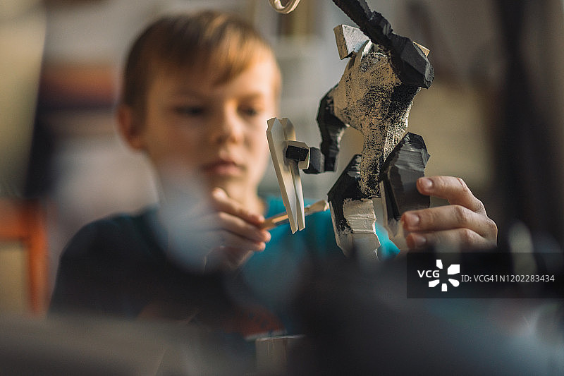 正在画机器人骨架的小男孩图片素材