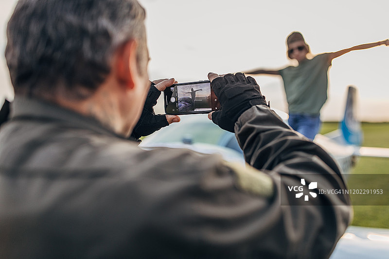 父亲飞行员给女儿拍照图片素材