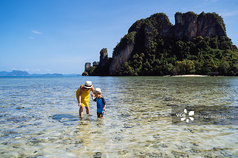 妈妈和儿子在帕克比亚岛海边欣赏宁静美丽的海景。图片素材