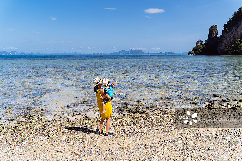 妈妈和儿子在帕克比亚岛海边欣赏宁静美丽的海景。图片素材