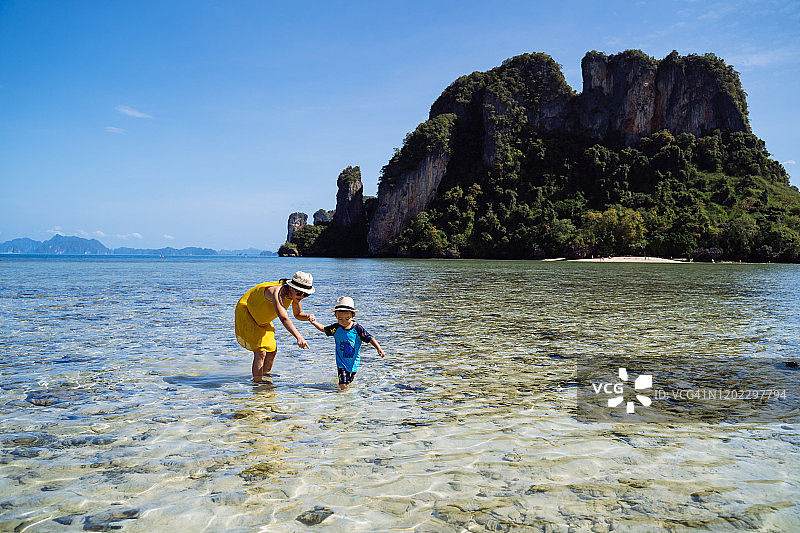 妈妈和儿子在帕克比亚岛海边欣赏宁静美丽的海景。图片素材