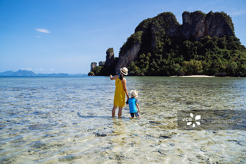 妈妈和儿子在帕克比亚岛海边欣赏宁静美丽的海景。图片素材