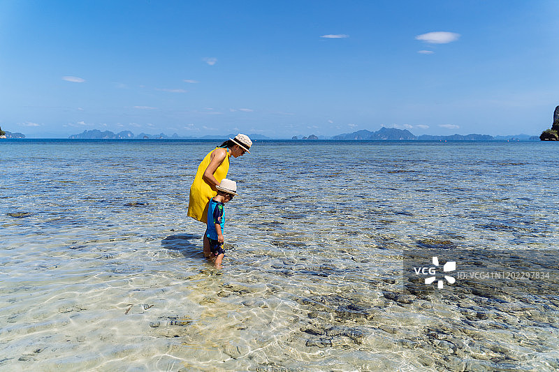 妈妈和儿子在帕克比亚岛海边欣赏宁静美丽的海景。图片素材