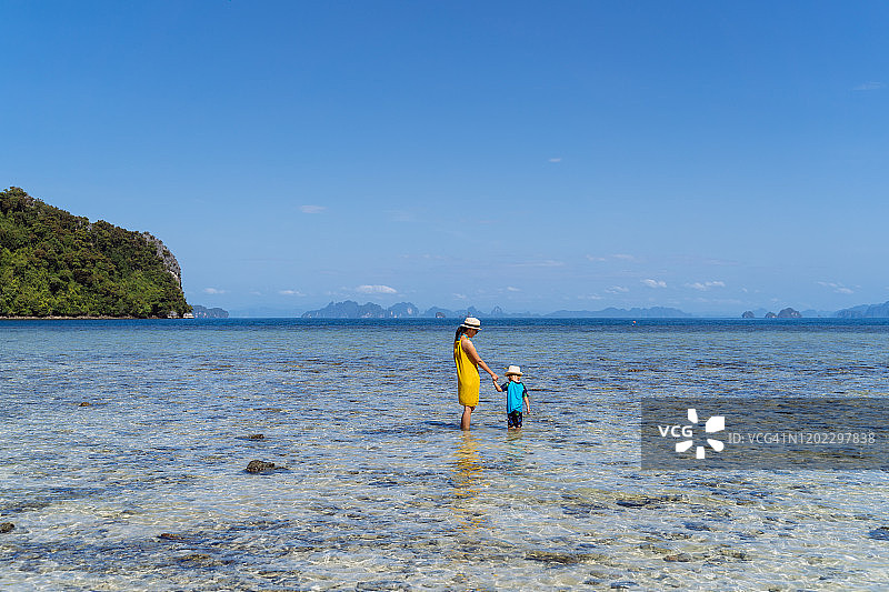 妈妈和儿子在帕克比亚岛海边欣赏宁静美丽的海景。图片素材