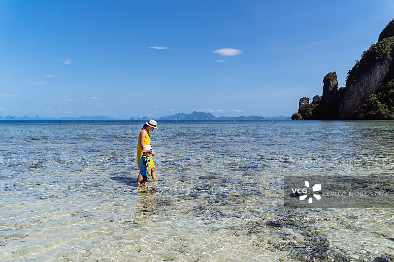 妈妈和儿子在帕克比亚岛海边欣赏宁静美丽的海景。图片素材