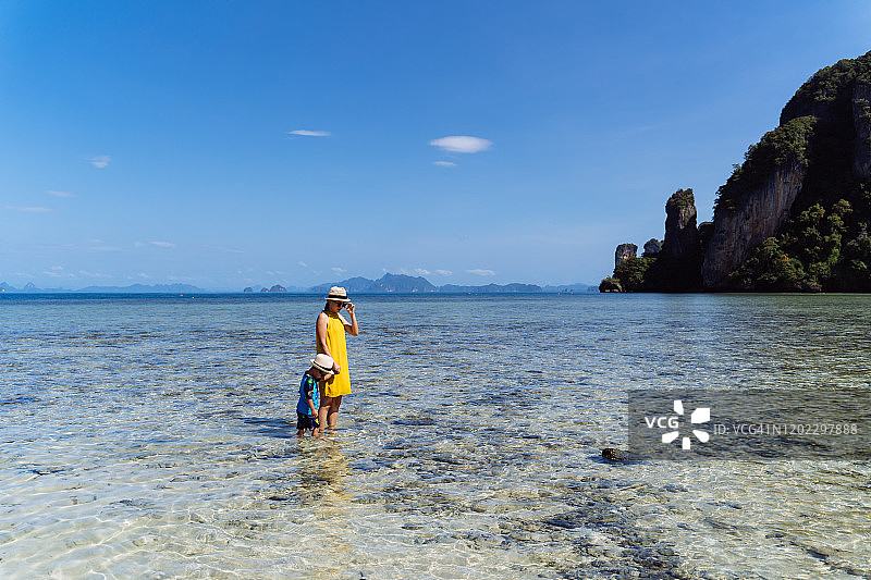 妈妈和儿子在帕克比亚岛海边欣赏宁静美丽的海景。图片素材