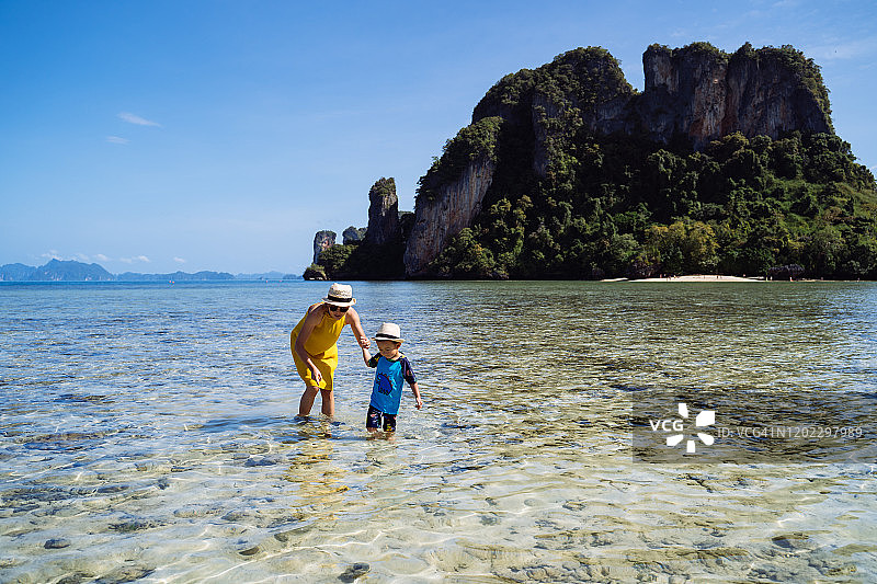 妈妈和儿子在帕克比亚岛海边欣赏宁静美丽的海景。图片素材