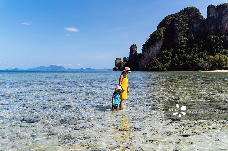 妈妈和儿子在帕克比亚岛海边欣赏宁静美丽的海景。图片素材