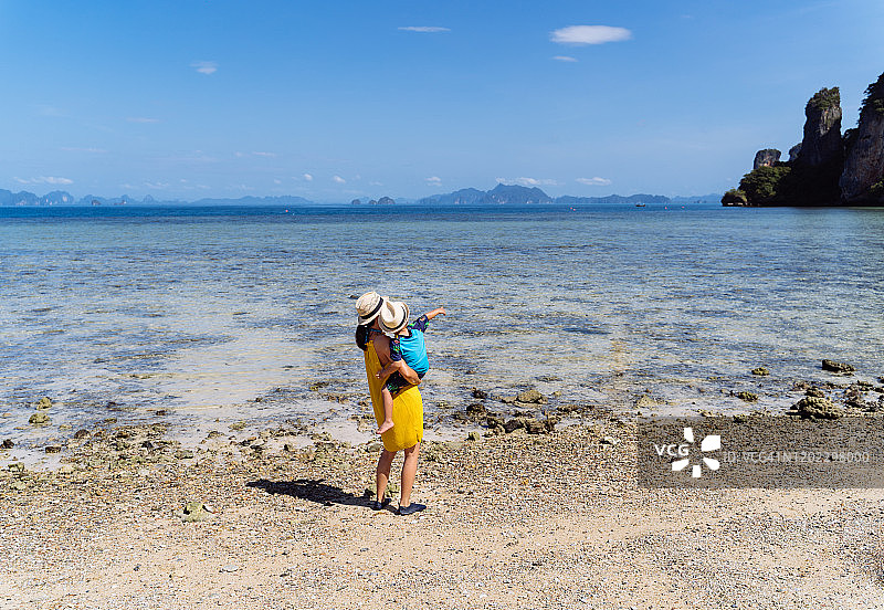 妈妈和儿子在帕克比亚岛海边欣赏宁静美丽的海景。图片素材