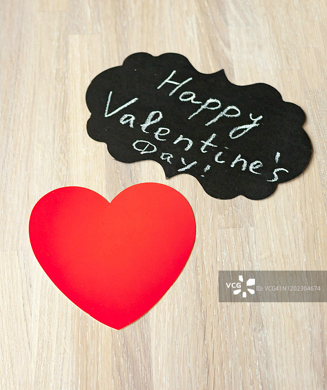 木质背景上带有情人节快乐标志的红心贺卡特写图片素材