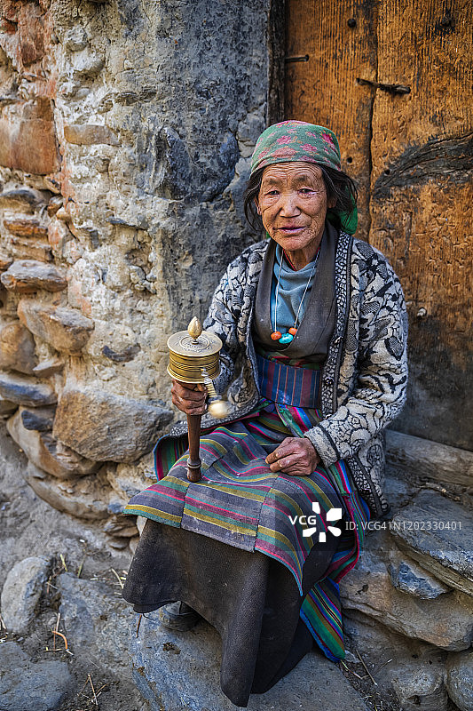 在房屋前祈祷的藏族群众，上木斯塘图片素材