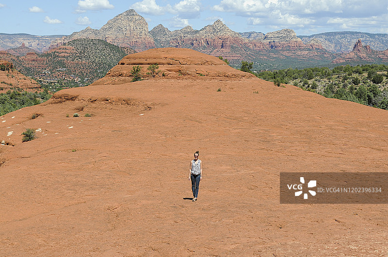 站在新墨西哥州圣菲红色岩石山脊上的女孩图片素材