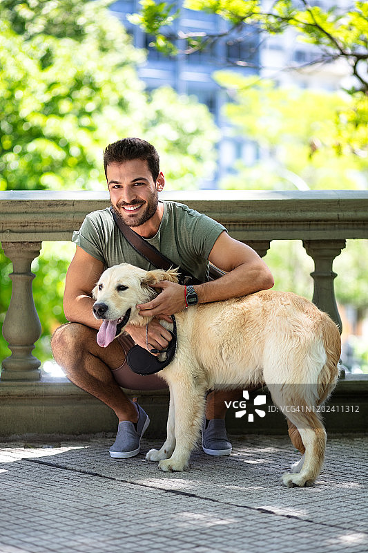 英俊的年轻男子与可爱的狗合影图片素材