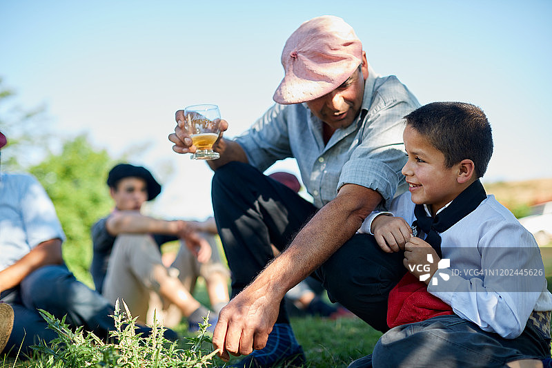 高乔父亲在烧烤炉旁听儿子讲话图片素材