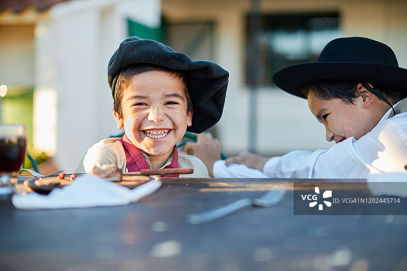 坐在桌旁看着相机的小男孩图片素材