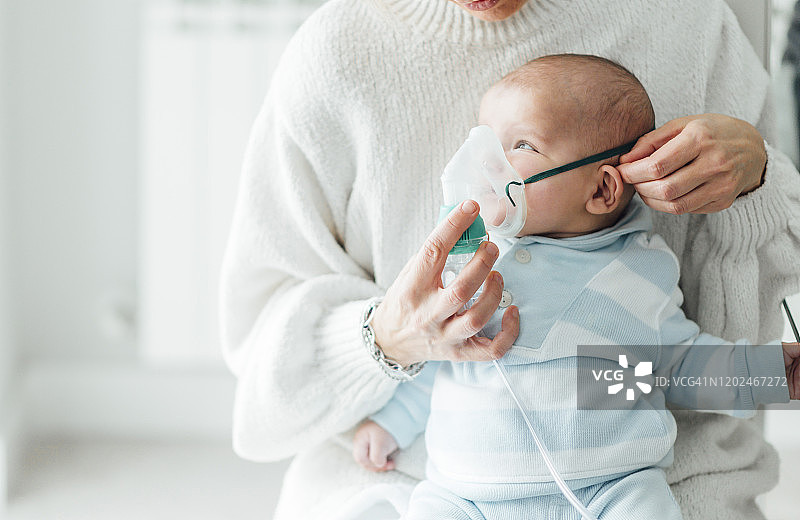 母亲给婴儿做呼吸治疗图片素材