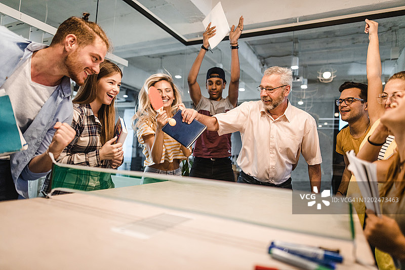 快乐的教授在校园与学生打乒乓球图片素材