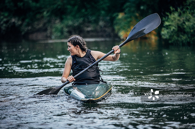 年轻女子在河里划桨图片素材