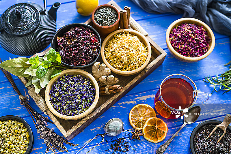 花草茶：蓝色桌上俯拍多种干茶花叶图片素材