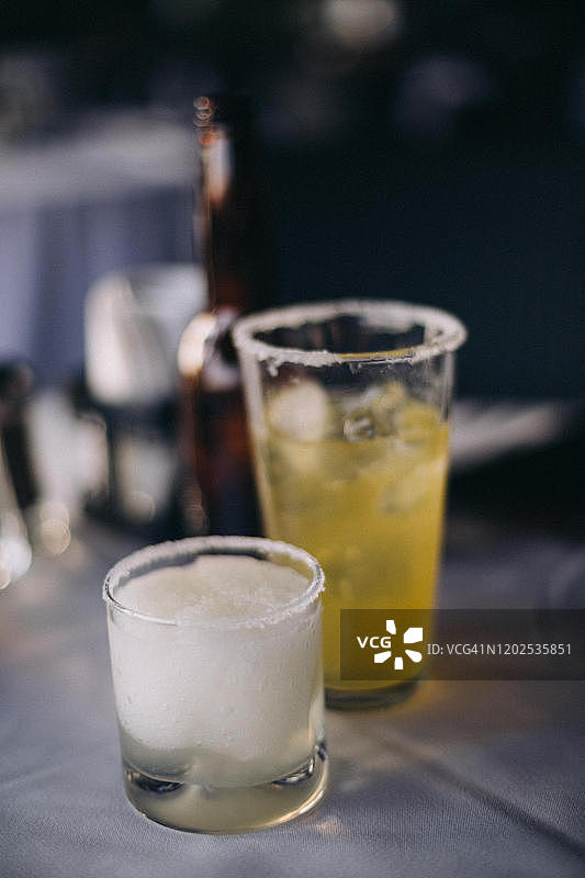 两杯龙舌兰酒鸡尾酒，杯沿蘸盐，位于墨西哥克雷塔罗一家餐厅的桌子上图片素材