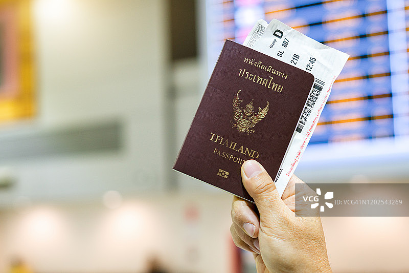 男人在机场手持护照和登机牌的特写图片素材