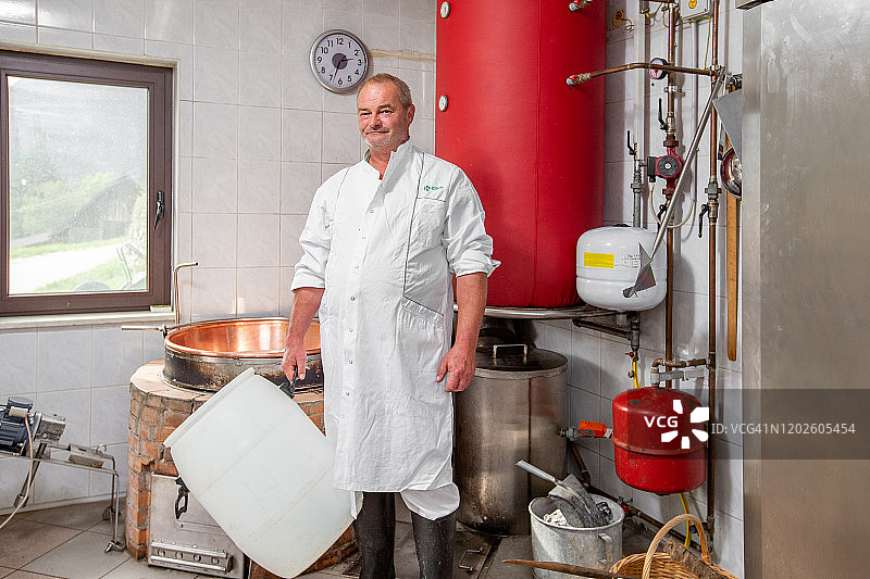 微笑的奶酪制造商手持空牛奶容器的横向照片图片素材