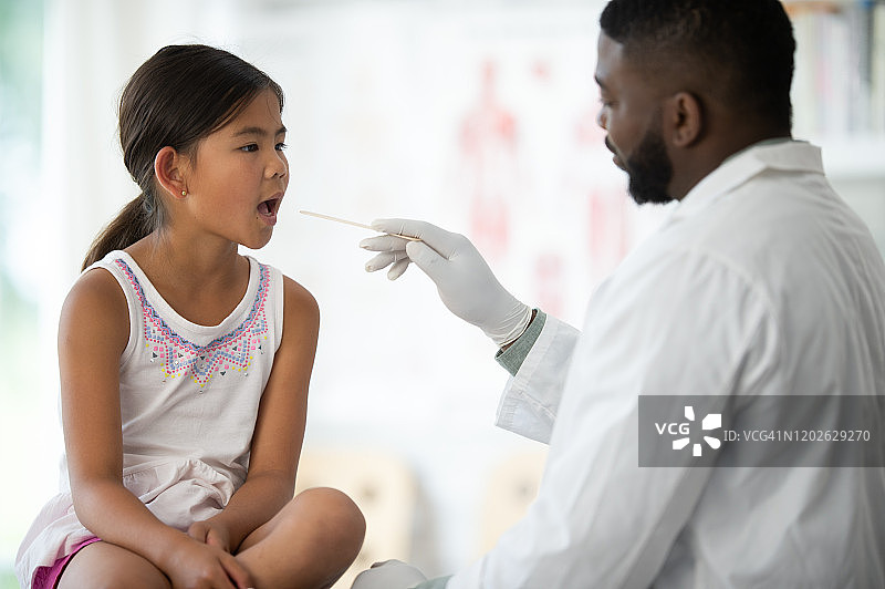 正在检查喉咙的亚洲年轻女孩图片素材