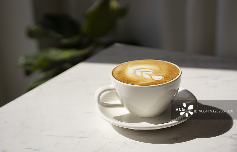光线下的卡布奇诺咖啡杯特写图片素材