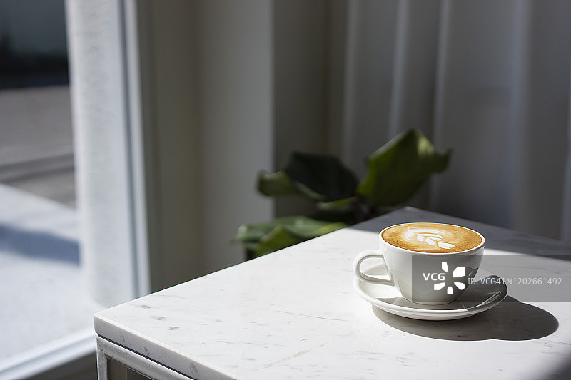 光线下的卡布奇诺咖啡杯特写图片素材