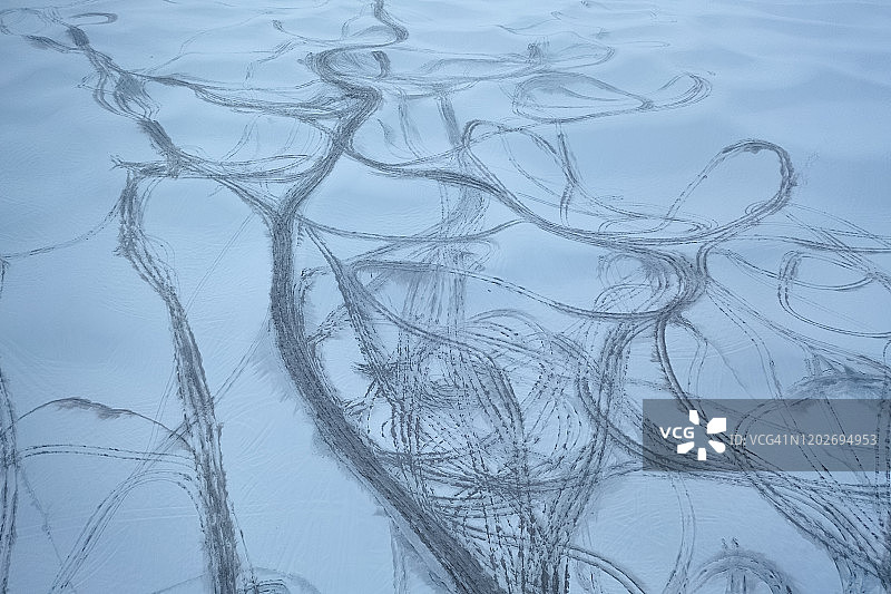 白雪覆盖的沙漠中轮胎痕迹航拍图片素材