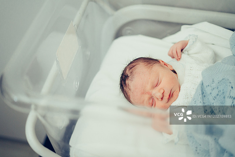 在医院摇篮里睡觉的新生婴儿图片素材