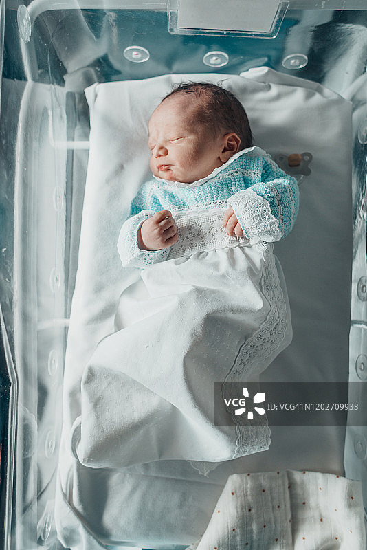 在医院摇篮里睡觉的新生婴儿图片素材