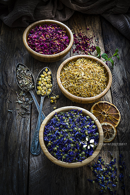 乡村木桌上的各色茶叶与花图片素材