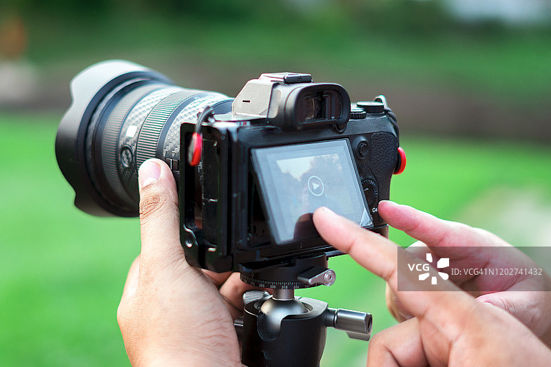 特写镜头：摄影师在数码单反相机上查看照片图片素材