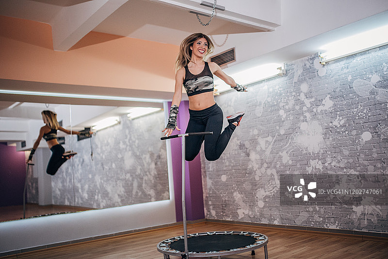 在迷你蹦床上锻炼的女人图片素材