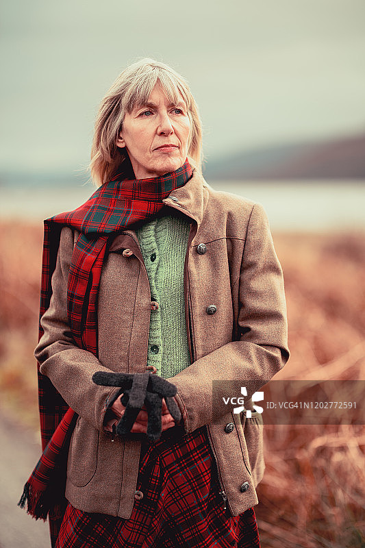 在苏格兰高地穿着红色格子呢的女人图片素材