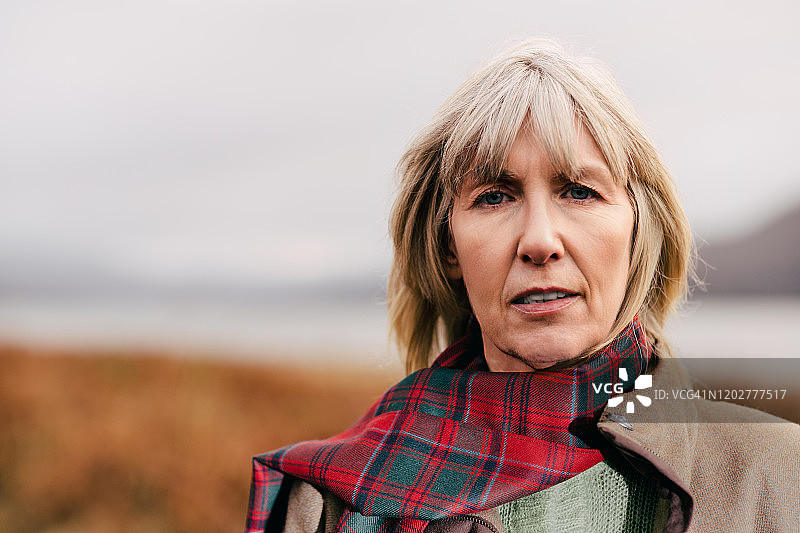 在苏格兰高地穿着红色格子呢的女人图片素材