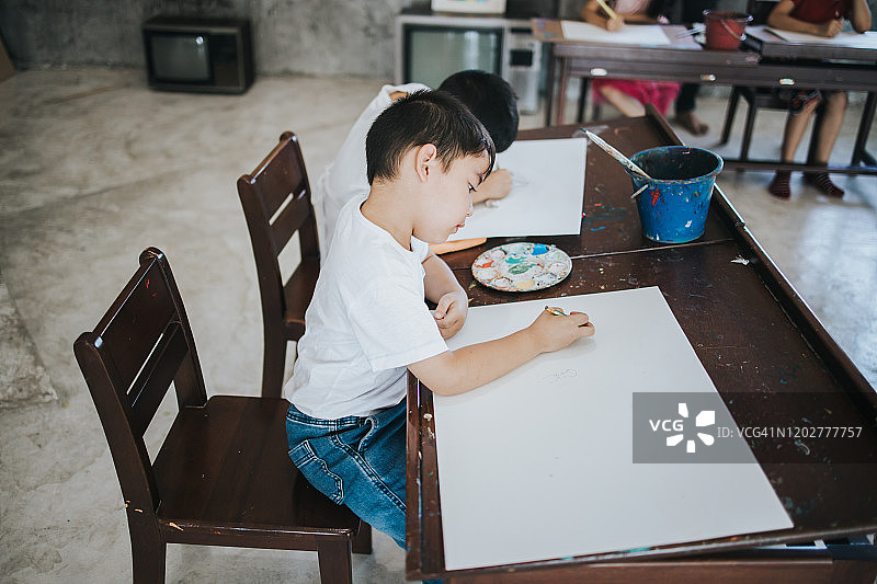 泰国儿童在学校学习时专注地绘画，充满积极的情绪和想象力图片素材