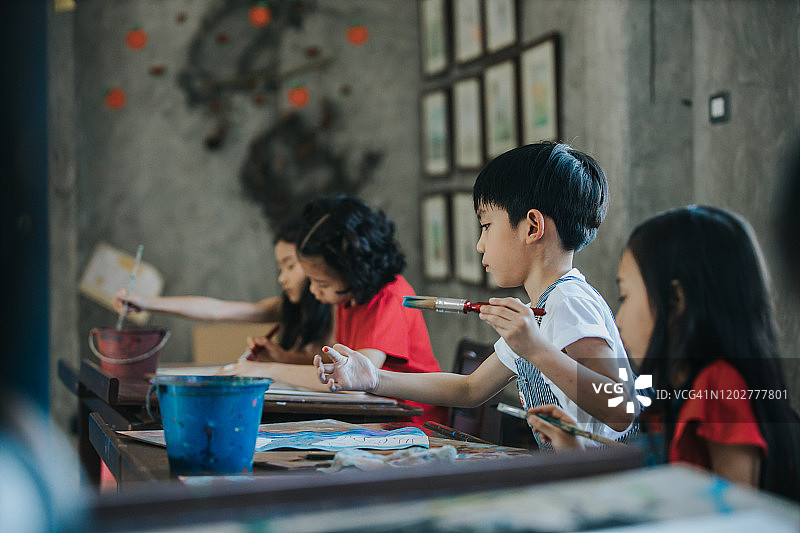 泰国儿童在学校学习时专注地绘画，充满积极的情绪和想象力图片素材