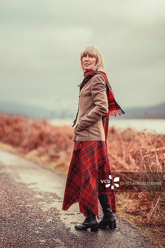 在苏格兰高地穿着红色格子呢的女人图片素材