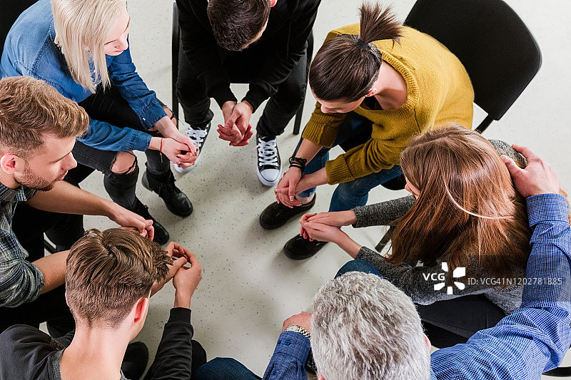 男人治疗师安慰年轻女学生图片素材