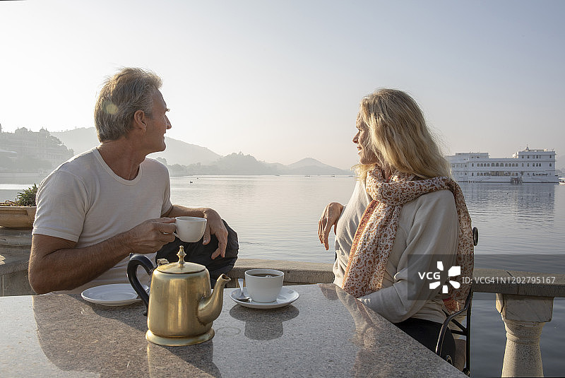 中年夫妇品茶，湖泊和水上宫殿为背景图片素材