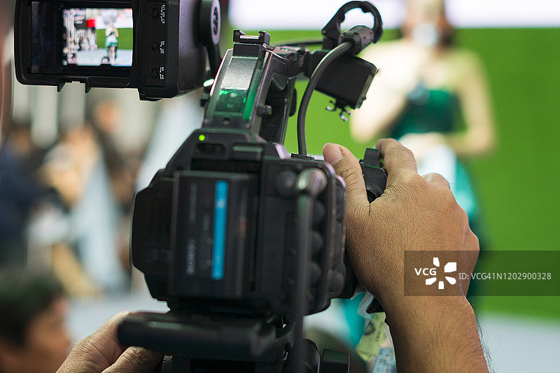 男子用电视摄像机拍摄人物，视频拍摄概念图片素材
