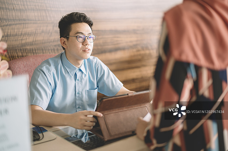 中国医院接待员为在前厅登记的顾客提供信息图片素材