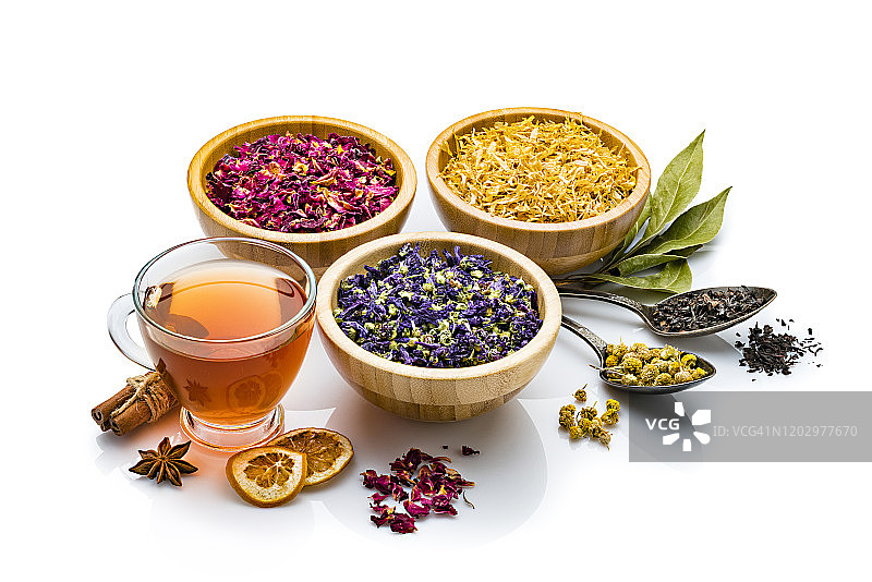 草药茶杯与各种彩色干燥茶叶和花朵，独立白色背景图片素材