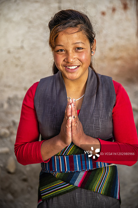 合十礼！尼泊尔上木斯塘的藏族女孩肖像图片素材